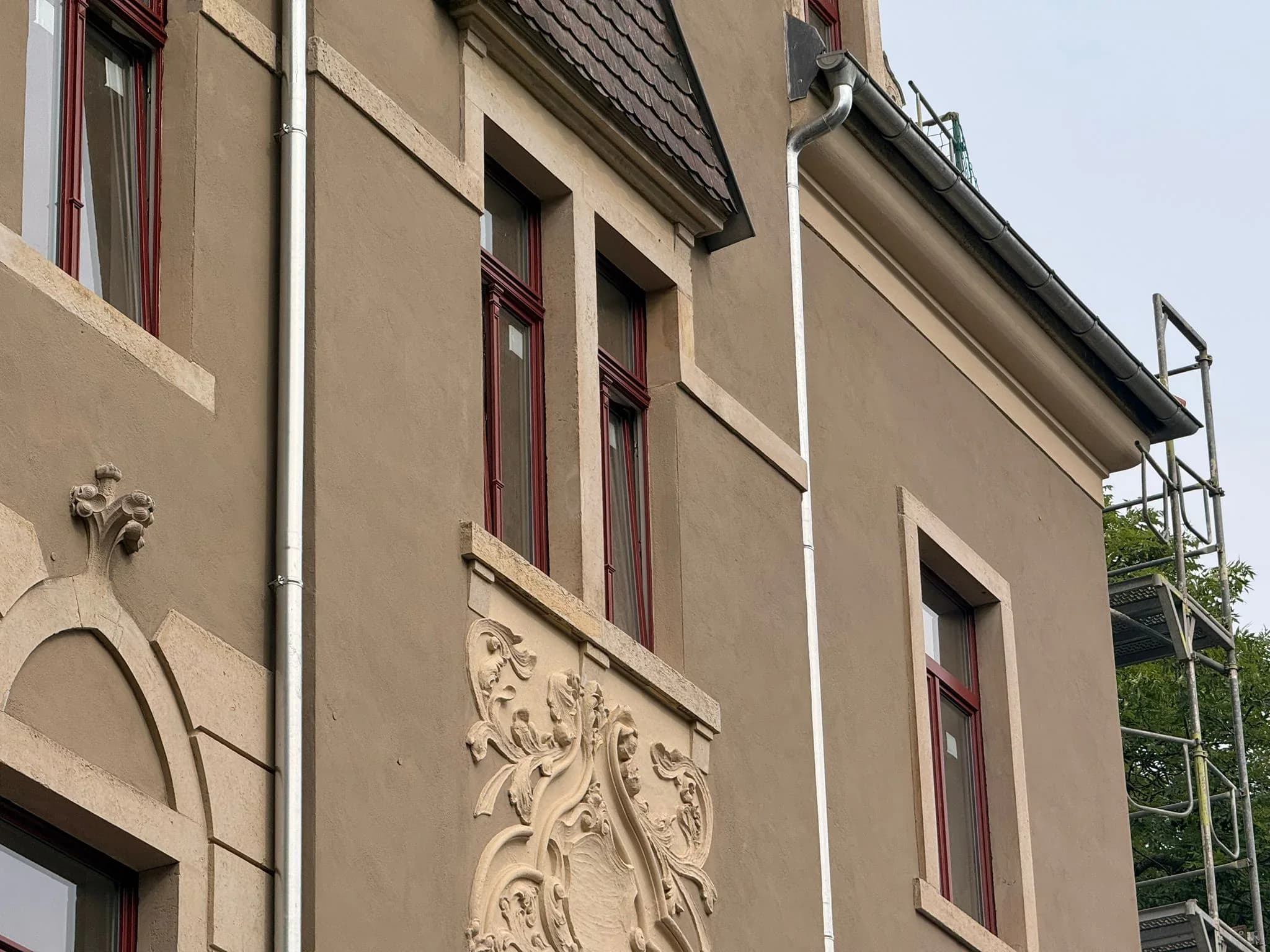 Schrägblick auf Fenster, Putzflächen und Fassadenschmuck
