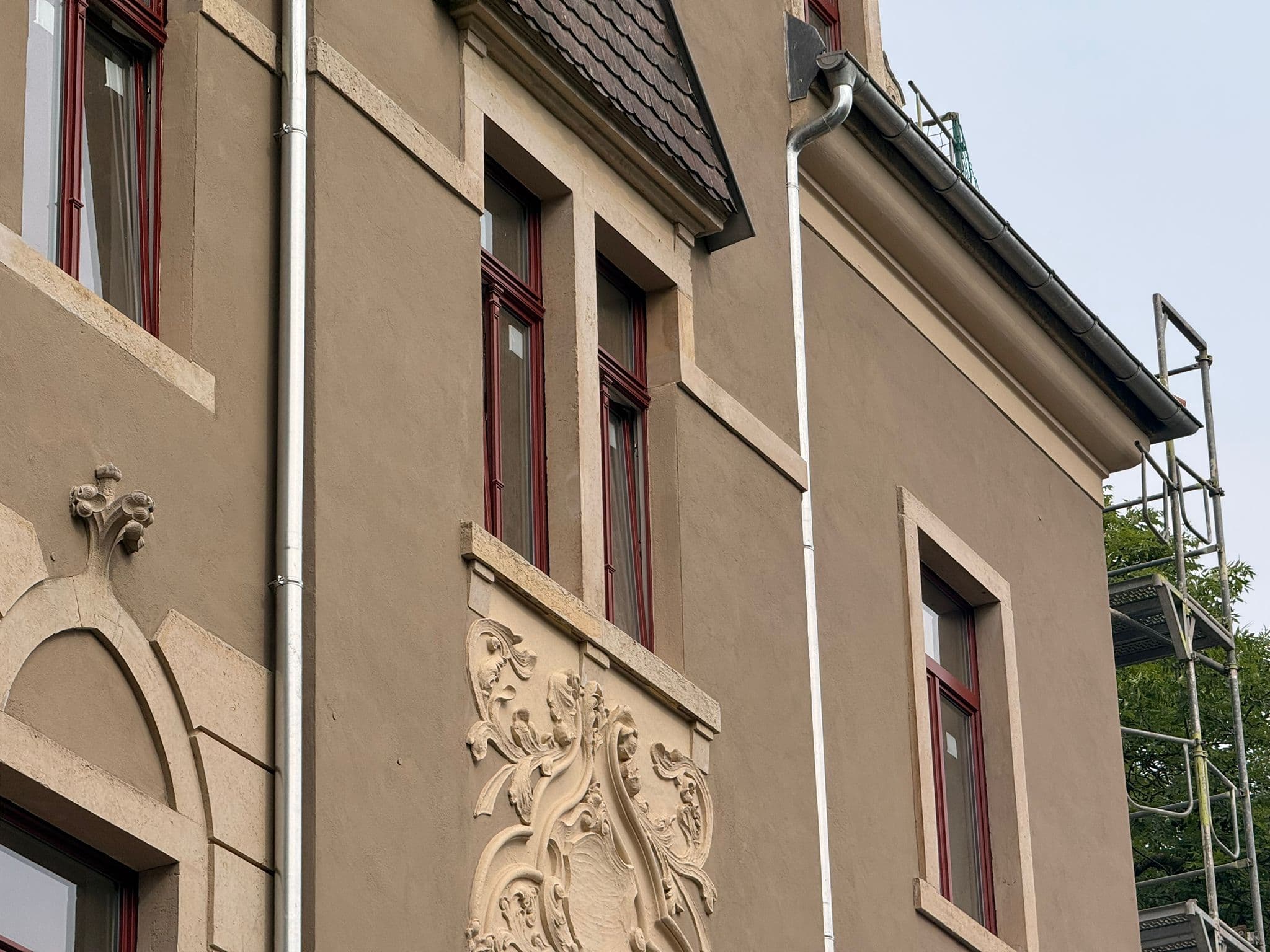 Schrägblick auf Fenster, Putzflächen und Fassadenschmuck